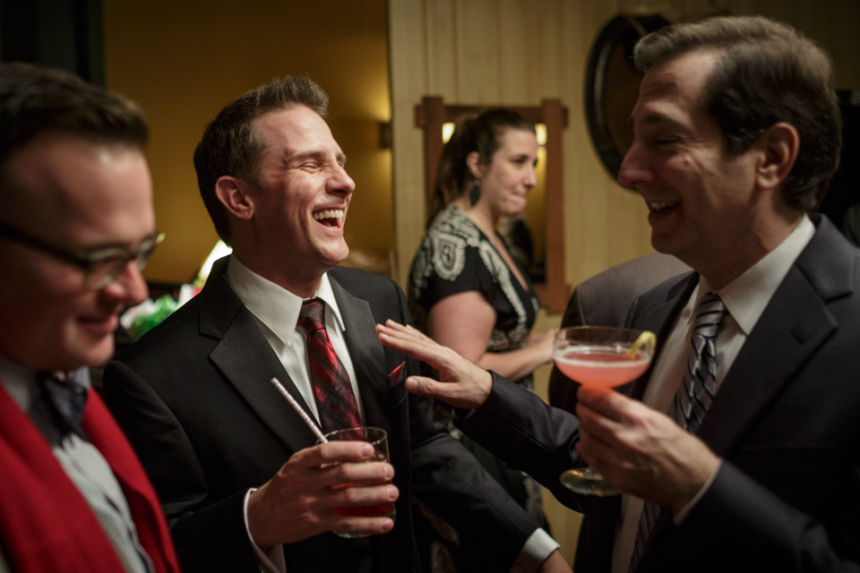 Chicago suburbs Gay Wedding Photographer captures groom laughing with guests during cocktail hour