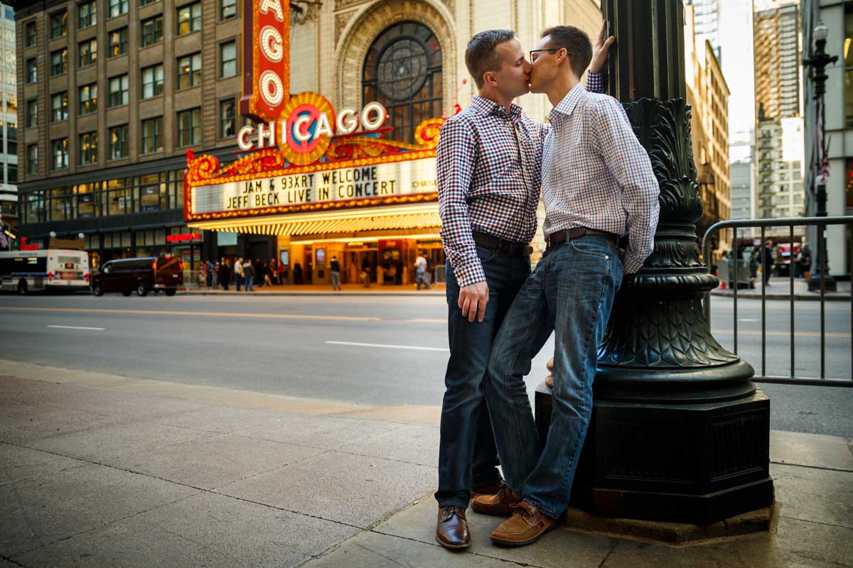 Illinois LGBT Wedding Photography engagement session with couple in front of the Chicago Theatre