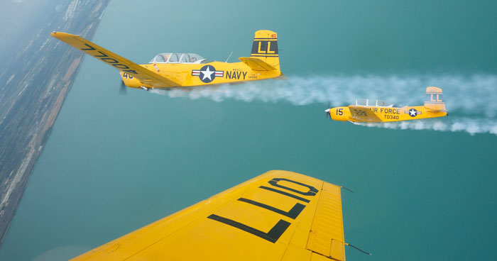 The Lima Lima Flight Team flys over Lake Michigan near the Gary / Chicago International Airport in Gary, Indiana, August 16, 2012. The team will take part in the 54th annual Chicago Air and Water Show August 18th and 19th. The planes, Beech T-34 Mentors, were used as training aircrafts for the U.S. Navy and Air Force duringthe 1940's. REUTERS/John Gress