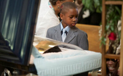 Ronnie Chambers Jr. looks down towards his collapsed mother Tahitah Myles during a funeral for the boys father Ronnie Chambers on February 4, 2013 in Chicago. Shirley Chambers of Chicago had four children - three boys and a girl. Now they're all gone. Her son, Ronnie Chambers. was the last of the single mother's children ' all victims of gun violence in Chicago over a period of 18 years.s. REUTERS/John Gress