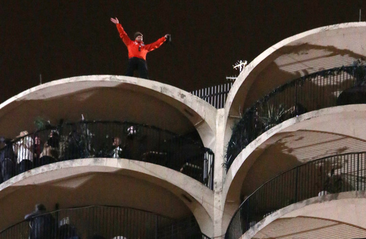 Daredevil Nik Wallenda waves after completing his blindfolded walk along a tightrope between two skyscrapers suspended 500 feet above Chicago, Illinois, November 2, 2014. REUTERS/John Gress
