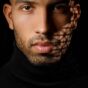 a up close headshot of a male model with shadows on the side of his face casted by light shining through grid