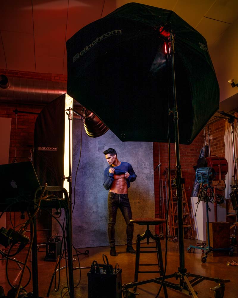 male model headshot on purple background behind the scenes