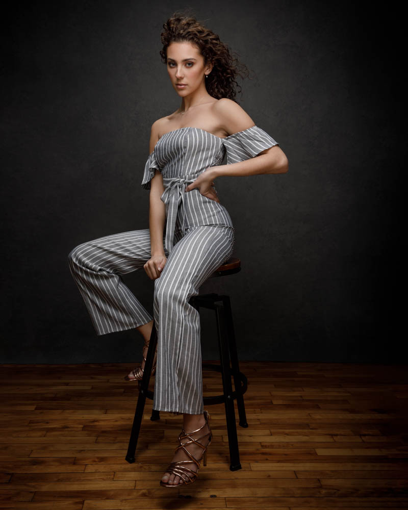 female model posed on stool wearing grey romper