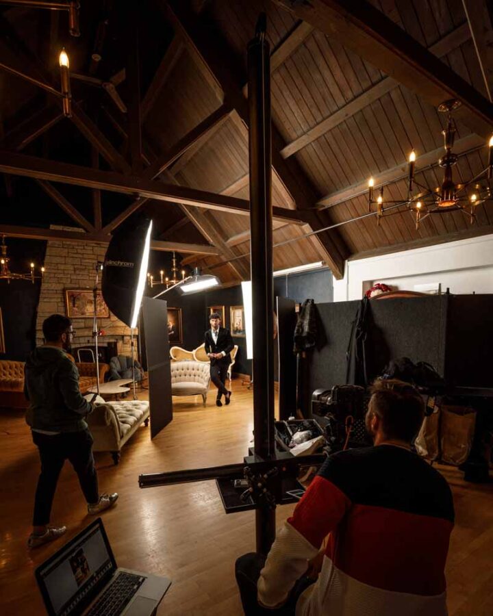 Kahil posing for a headshot as stylist Pablo adjusts details and photographer John Gress oversees the shoot.