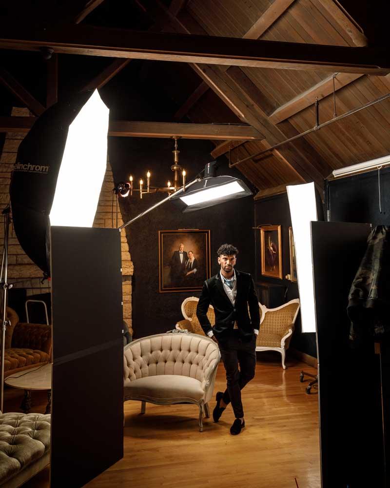 Kahil posing in a studio setting with a detailed view of the professional lighting setup used by John Gress.