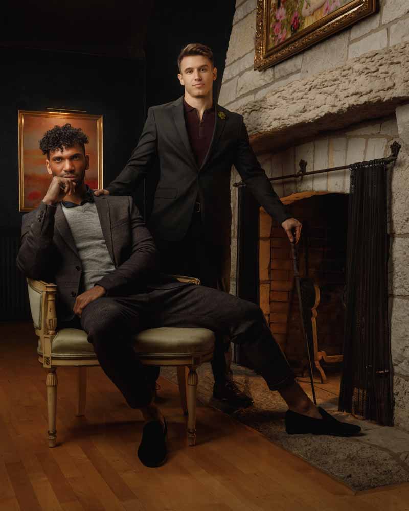 Sam and Kahil posing next to the fireplace in John Gress Photography's studio, exuding professionalism and style.