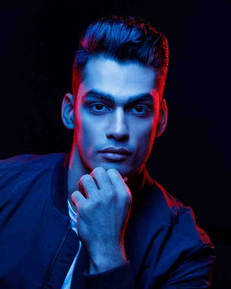 Akshay's headshot illuminated with vibrant red and blue lighting, demonstrating the creative potential of color to make a headshot pop and capture attention.