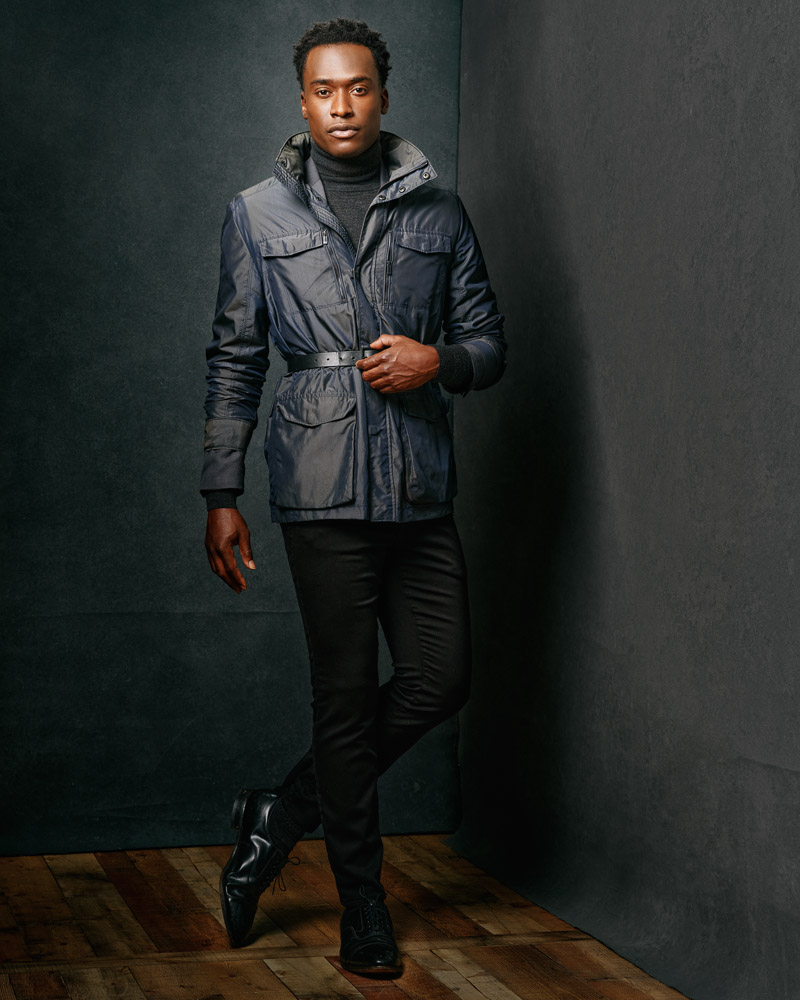 Full-body portrait of Justin in black jeans and a gray coat