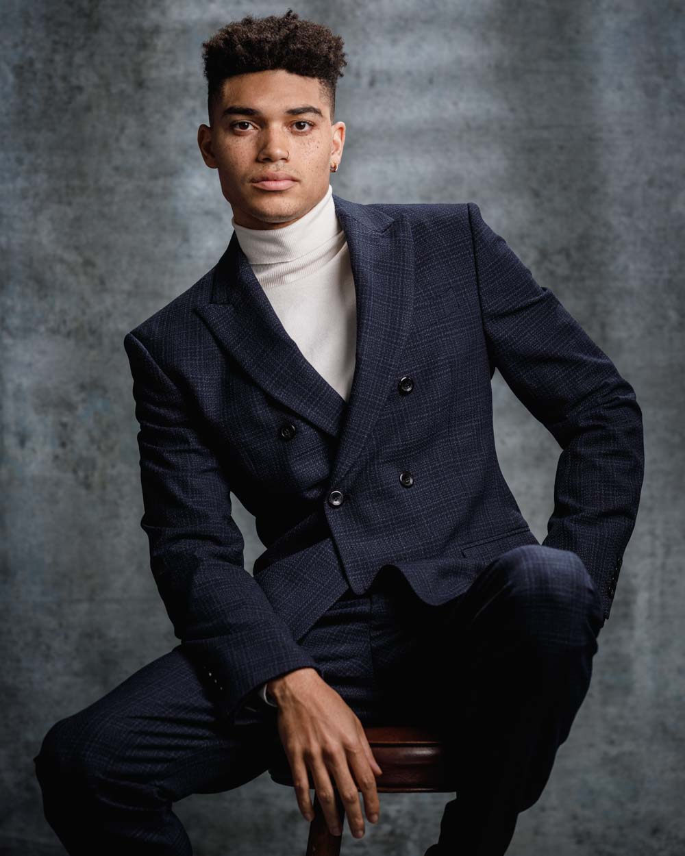 Kjay in a double-breasted blue suit, embodying sophistication during a model headshot session in Chicago