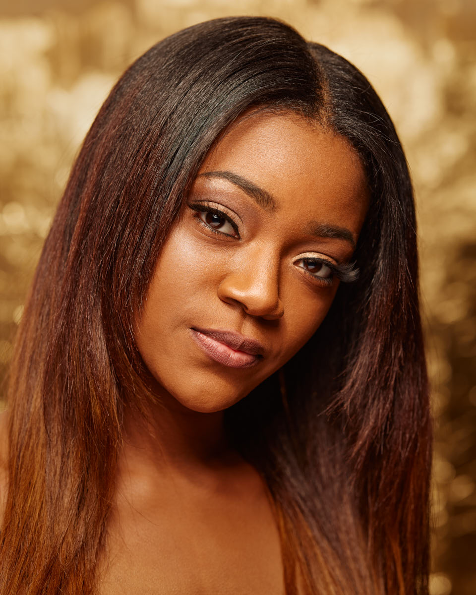 this is a beautiful headshot of Veronica with a golden backdrop and warm light