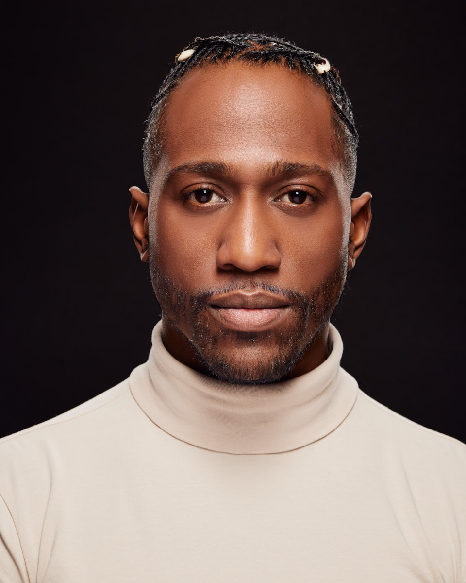 In this Chicago acting headshot of Preston is looking directly into the camera with a confident expression. He is wearing a light turtleneck, and the dark background brings focus to his face.