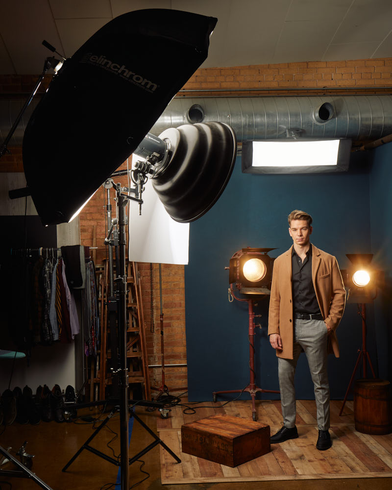 Behind the scenes of Erik's photoshoot in a stylish overcoat against a classic backdrop