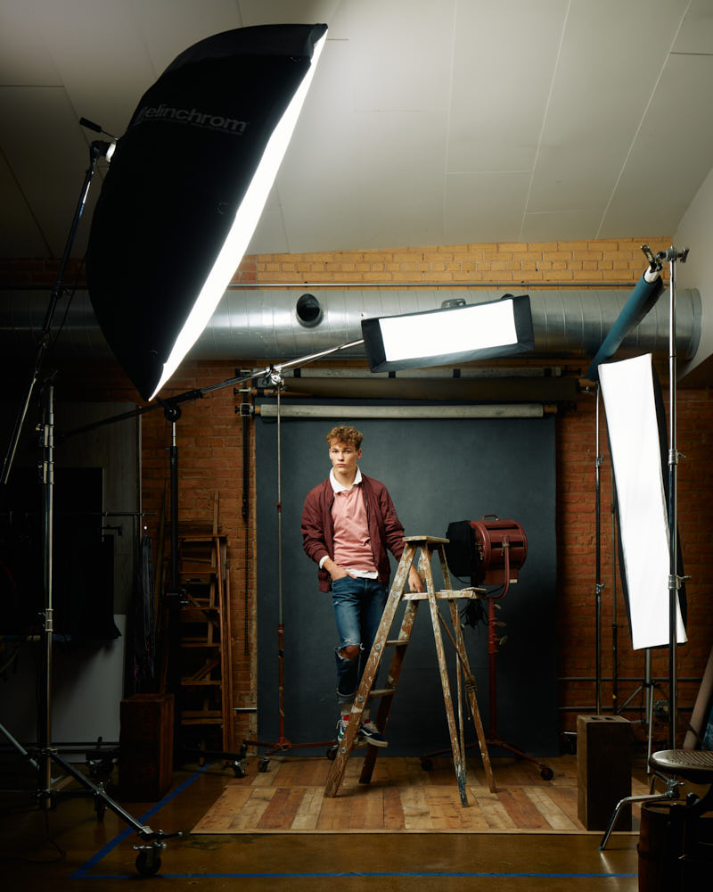 Professional portfolio photographer in Chicago - Evan in casual clothing, posing with antique props