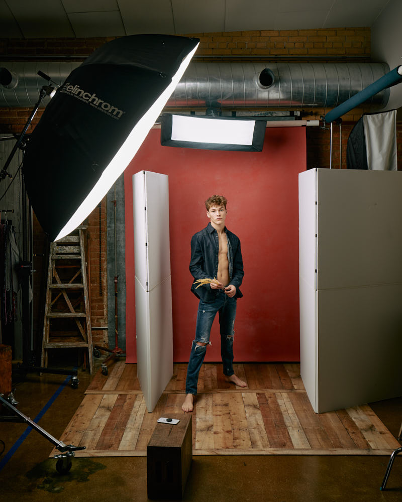 Evan behind the scenes on set, surrounded by lighting equipment