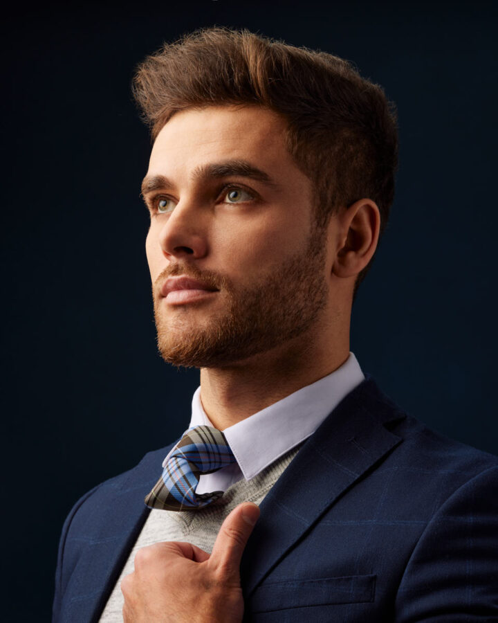Studio model photography in Chicago headshot of Constantine in a blue suit, jacket and tie, looking off to the side