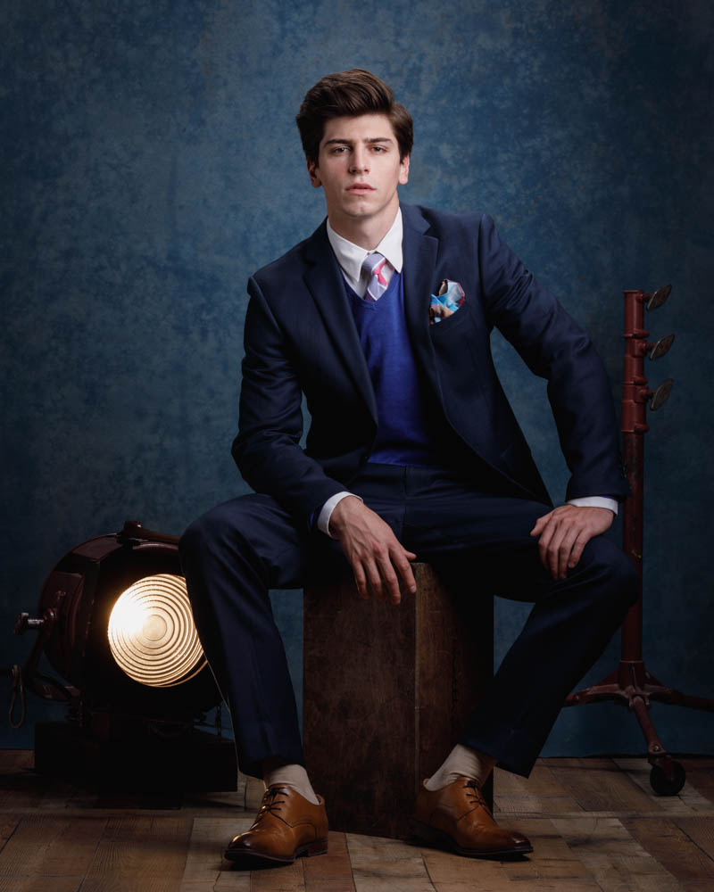 Noah is sitting on a wooden box for a modeling portfolio photographer in Chicago