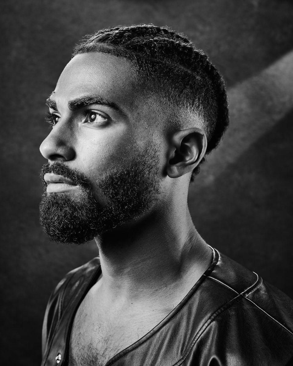 Shomari is captured in a studio setting, shirtless and in a boxing stance. The photographer captures him mid-pose, highlighting the intensity and dynamism of the shoot.