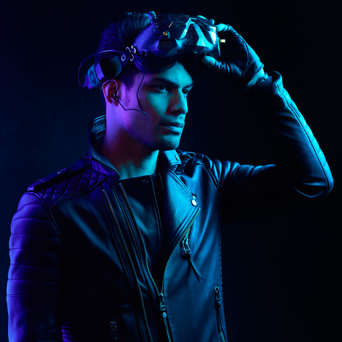 Editorial Portrait Photography in Chicago -The male model wearing the helmet and gloves, looking to the side in a dramatic blue-lit environment, with a focused and intense look.