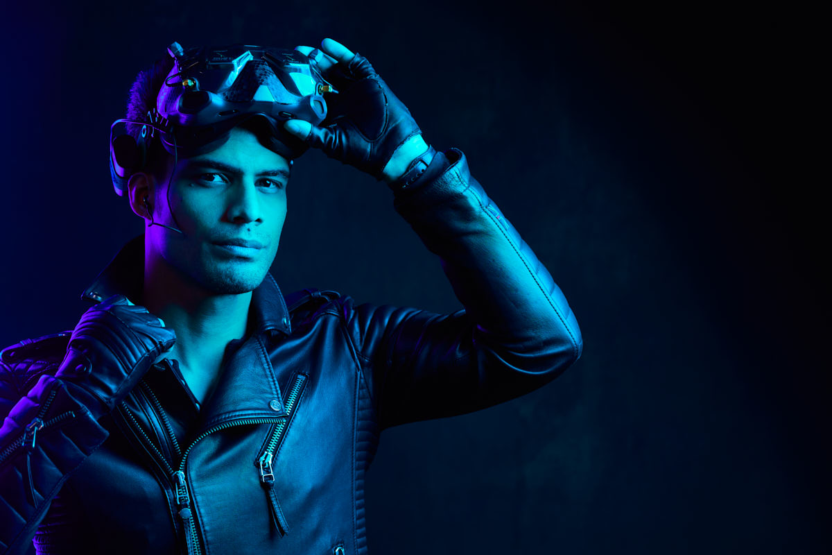 Editorial Portrait Photography in Chicago -The male model in a relaxed pose, seated and wearing a leather jacket and a beanie, with a casual and approachable demeanor against a dark background.