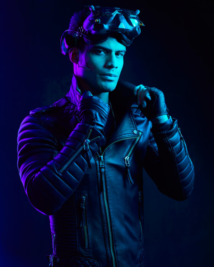 The male model again in the leather jacket and helmet, posed against a dark blue background, exuding a confident and bold presence.