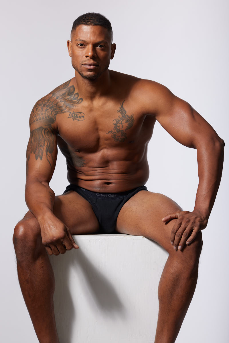 Seated portrait in Calvin Klein underwear, showing a confident and powerful pose.