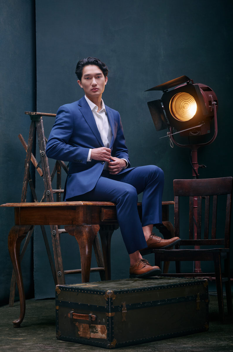 l Kyle wearing tailored blue suit in editorial studio setting