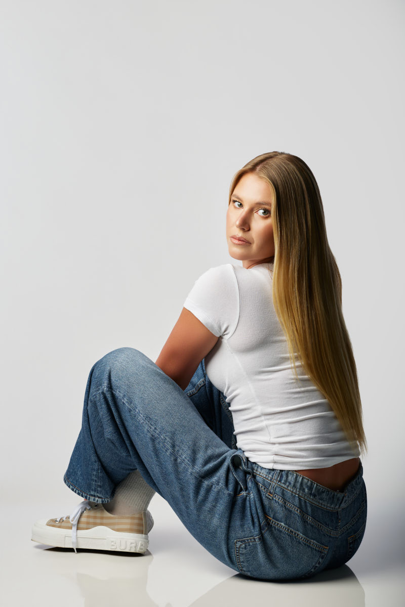 Mackinzie demonstrates versatility with a relaxed seated pose that highlights her natural beauty and commercial modeling appeal.