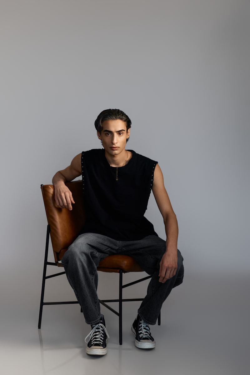 Male fashion model Giorgio seated confidently in a leather chair during a Male Fashion model portfolio Chicago photoshoot.