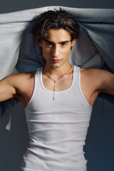 Close-up fashion portrait of Giorgio in a white tank top with a hoodie draped overhead for a Male Fashion model portfolio Chicago.