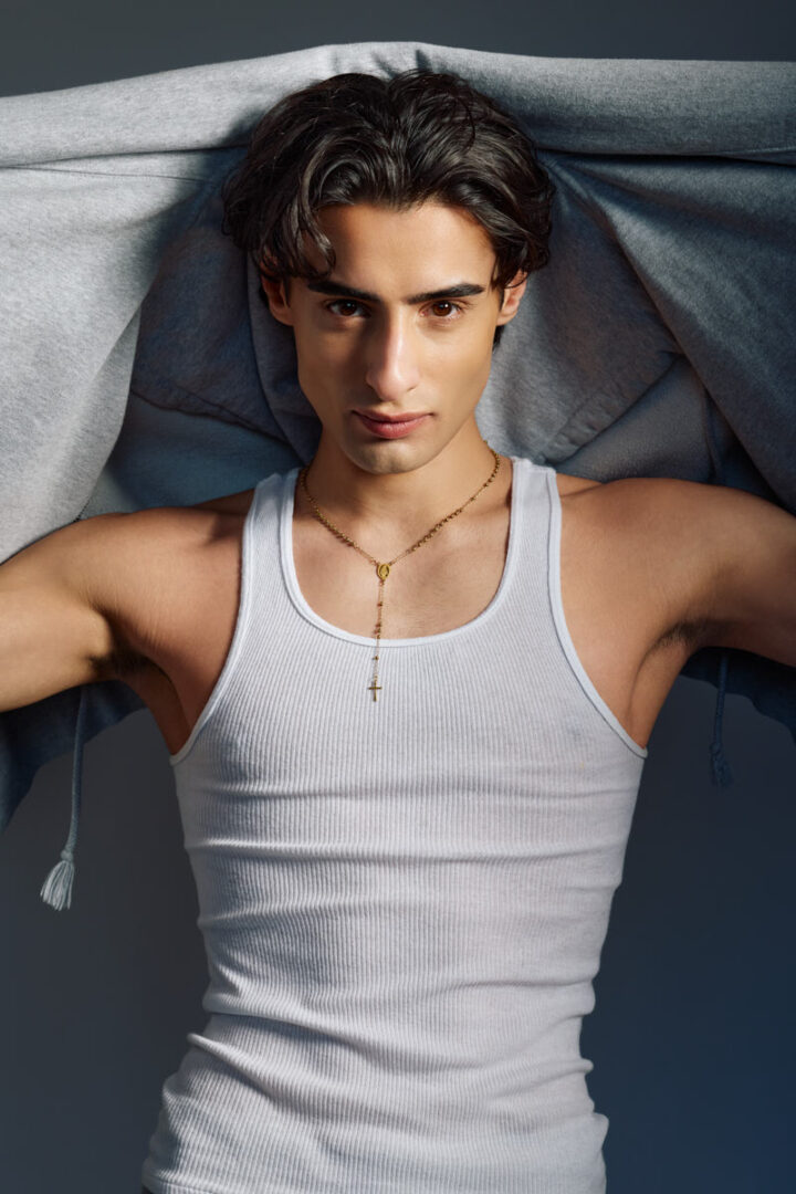 Close-up fashion portrait of Giorgio in a white tank top with a hoodie draped overhead for a Male Fashion model portfolio Chicago.