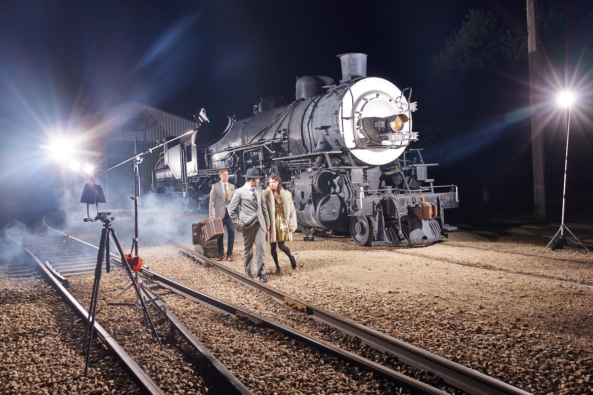 Chicago Magazine Editorial Photographer -Another behind-the-scenes shot capturing the dynamic movement and setup of the photoshoot, with the train prominently featured in the background.