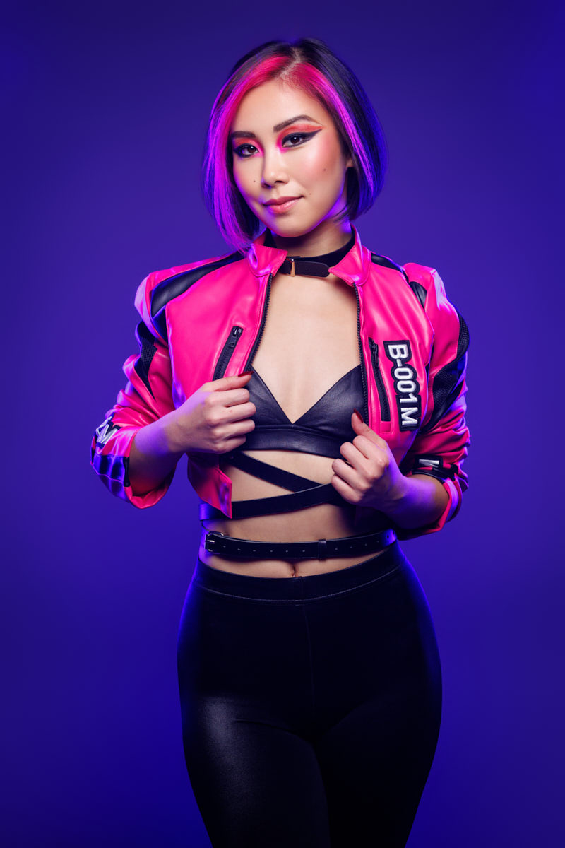 Music marketing photography Chicagoo portrait of Tianqing in a hot-pink and black jacket against a purple background